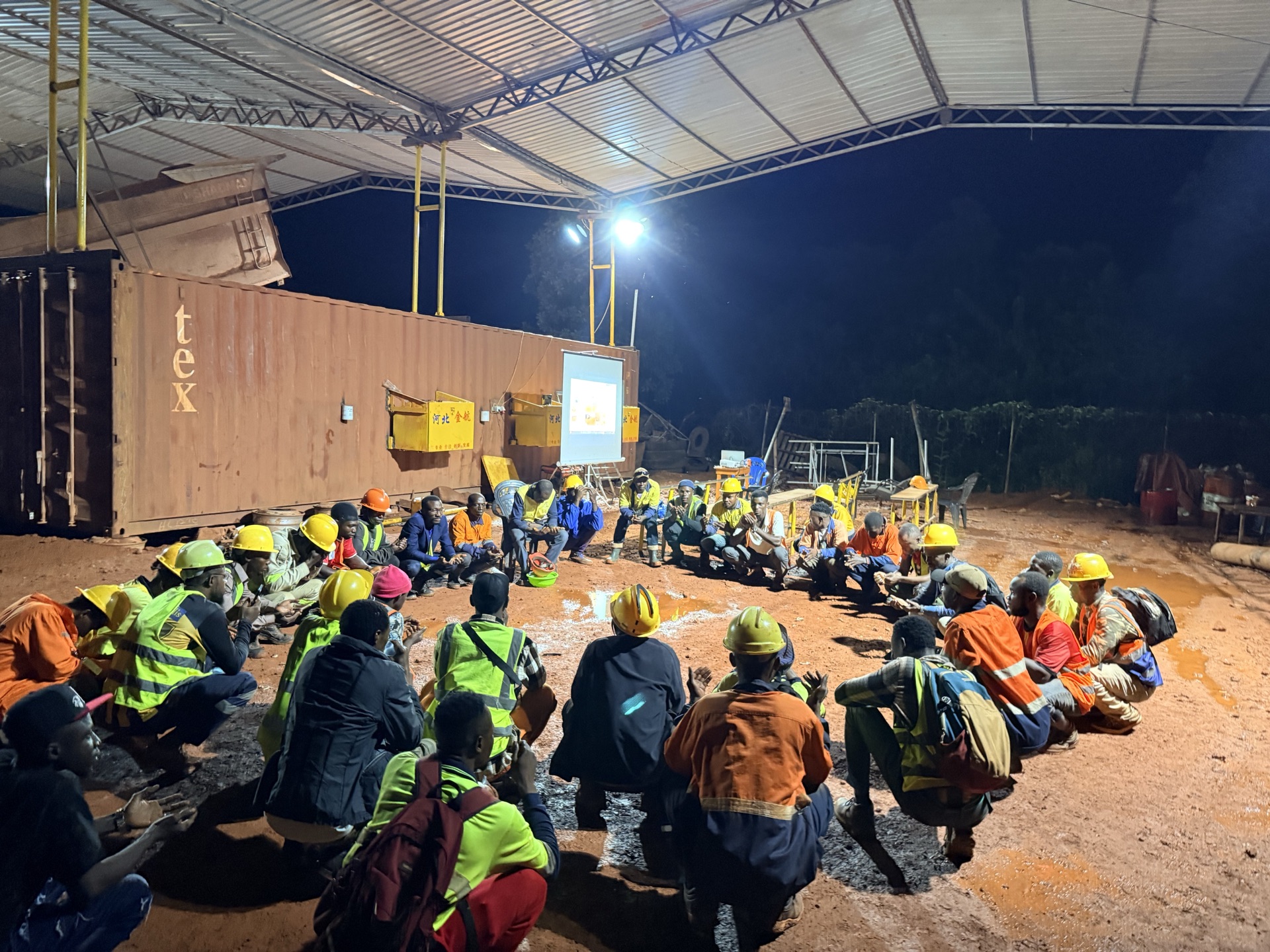 Night safety debrief with workers gathered in a circle